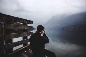 Man looking out over a lake. Socially anxious introvert