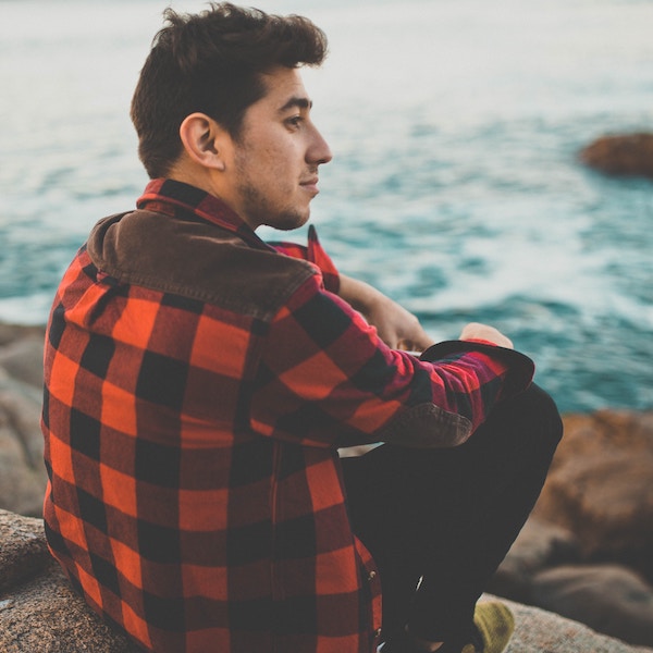 Man in flannel looking at ocean
