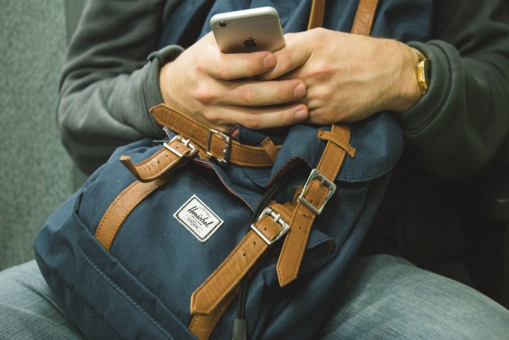 Man on Phone with Bag - How to Get Matches on Hinge