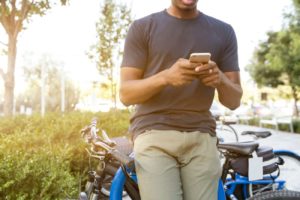 Man Texting Beside Bike - Should I Text Her First
