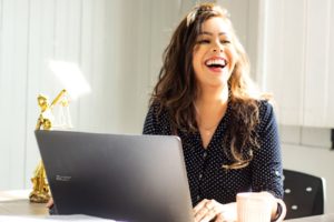 Woman at Computer Laughing - Online Dating Coach