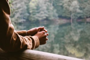 person looking over railing into nature - body language for attraction