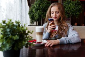 Woman With Phone And Coffee - If She Doesn't Text Back Is She Not Interested